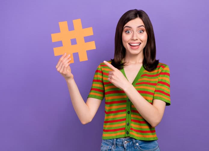 Mulher segurando um símbolo de hashtag