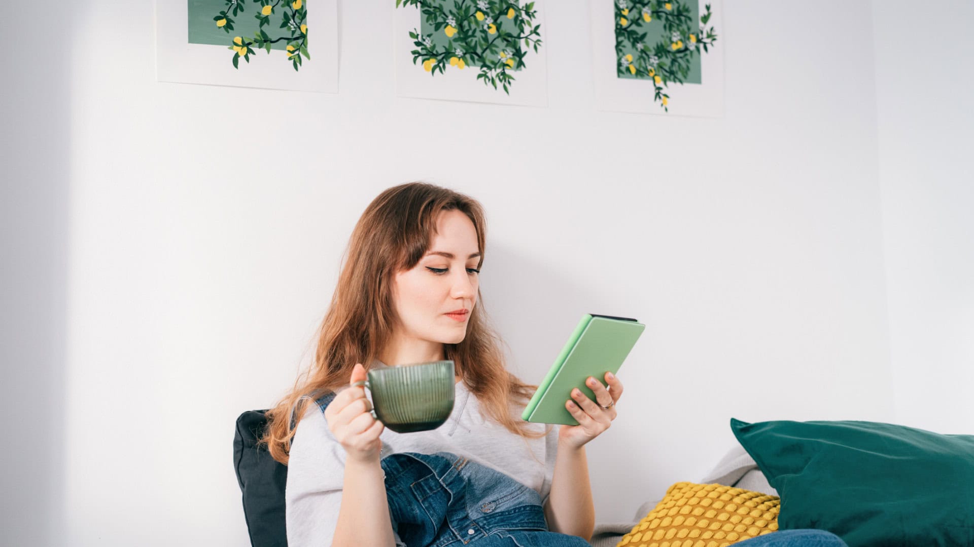 Mulher tomando chá e segurando um Kindle
