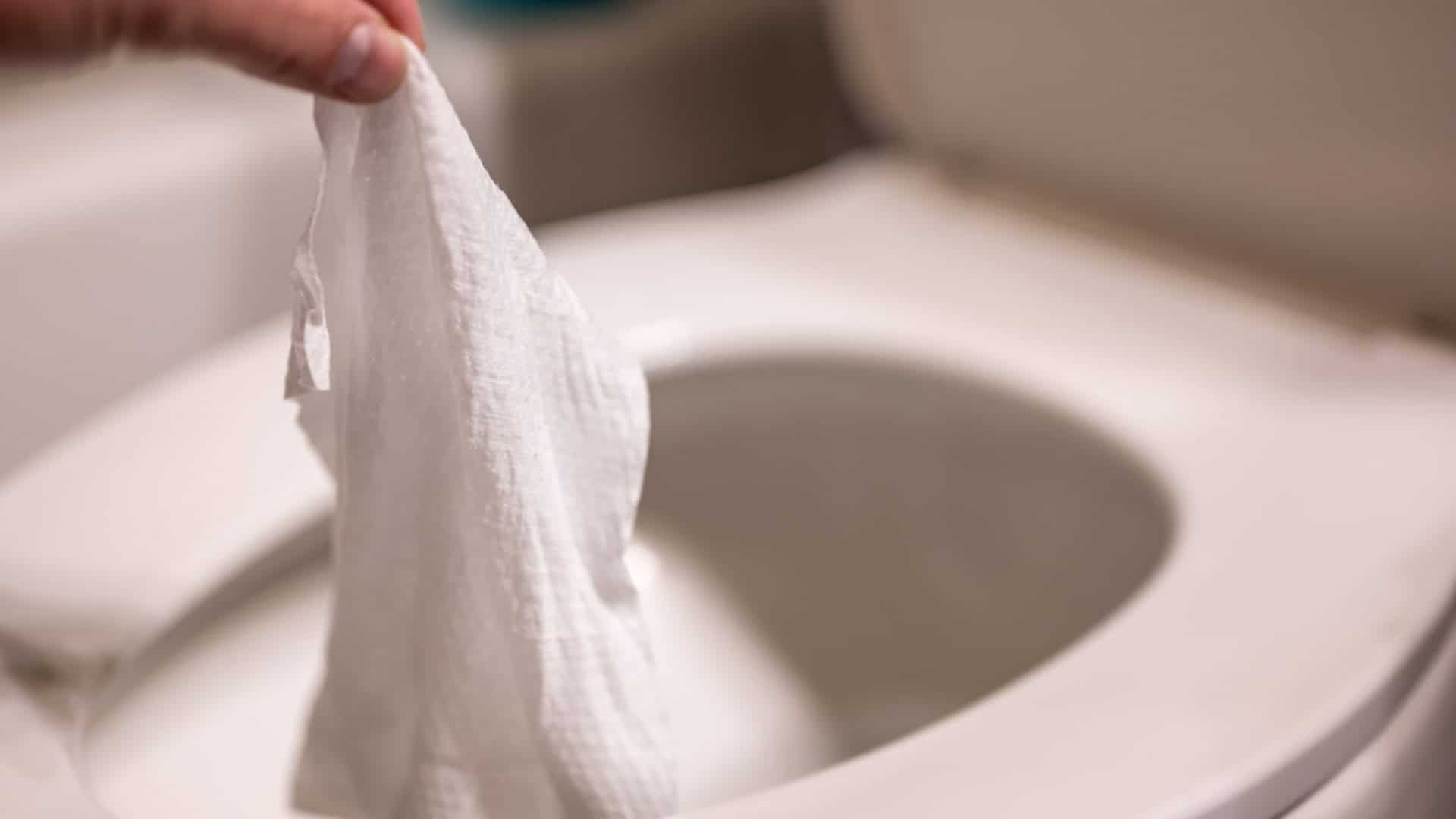 Pessoa descartando um lenço em um vaso sanitário
