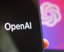 Logo da OpenAI em um smartphone e ao fundo