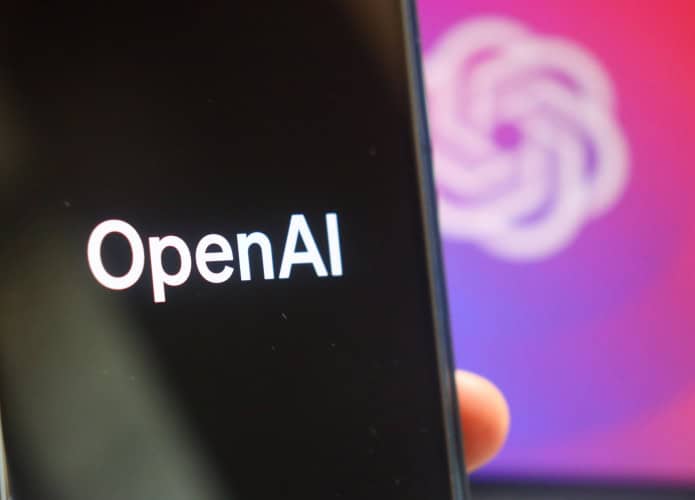 Logo da OpenAI em um smartphone e ao fundo
