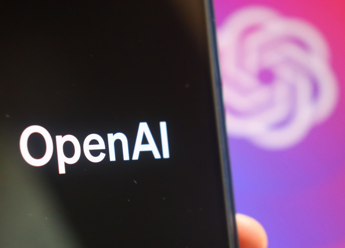 Logo da OpenAI em um smartphone e ao fundo