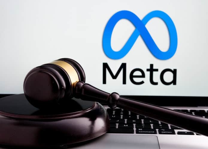 Ao fundo, logo da Meta na tela de um notebook; à frente, um martelo de juiz