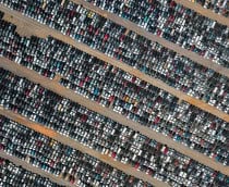 Pátio com centenas de carros estacionados visto de cima