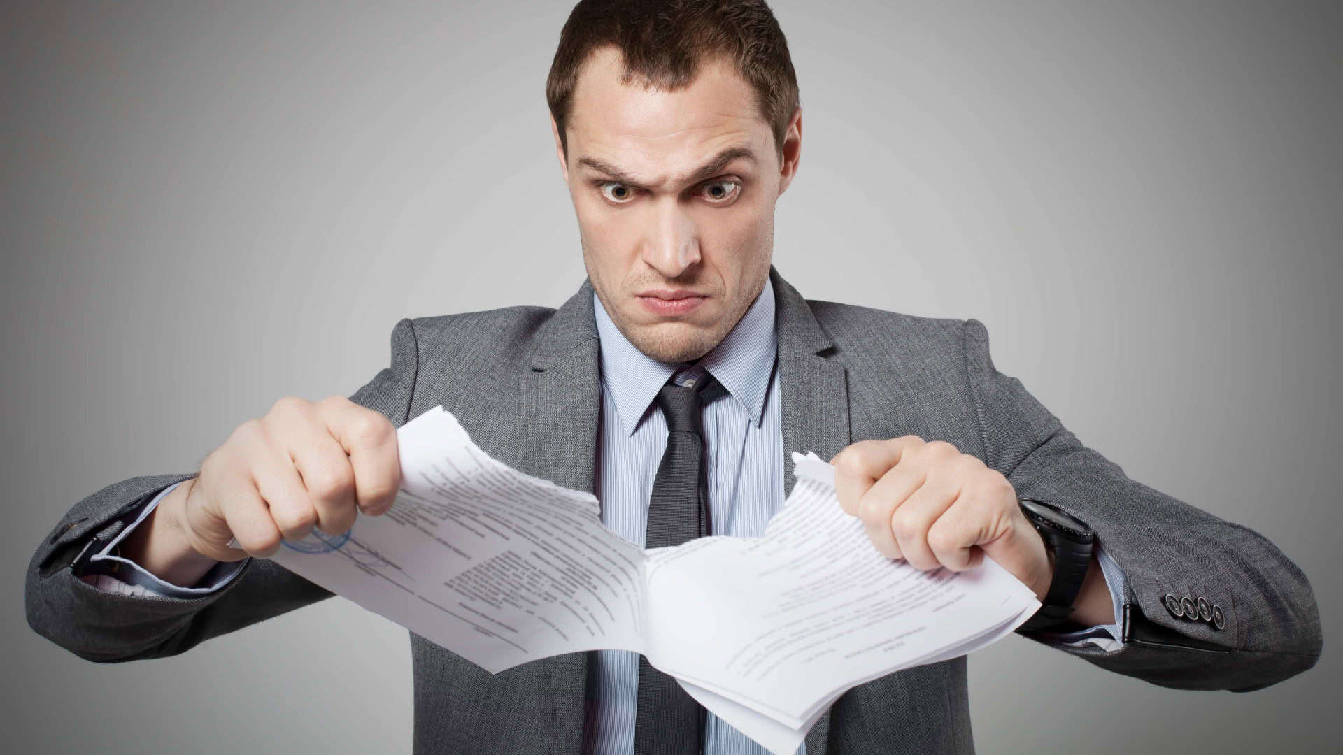 Homem rasga contrato de papel