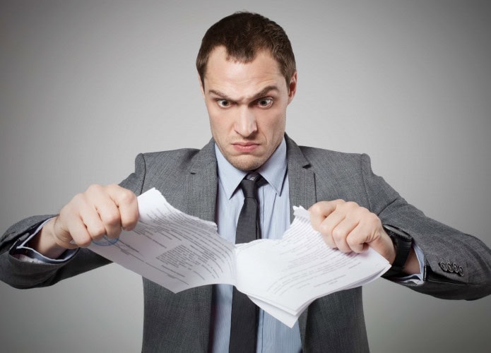 Homem rasga contrato de papel