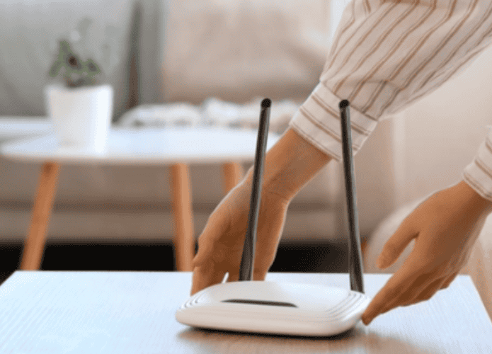 mulher colocando roteador em cima de mesa em um ambiente de sala