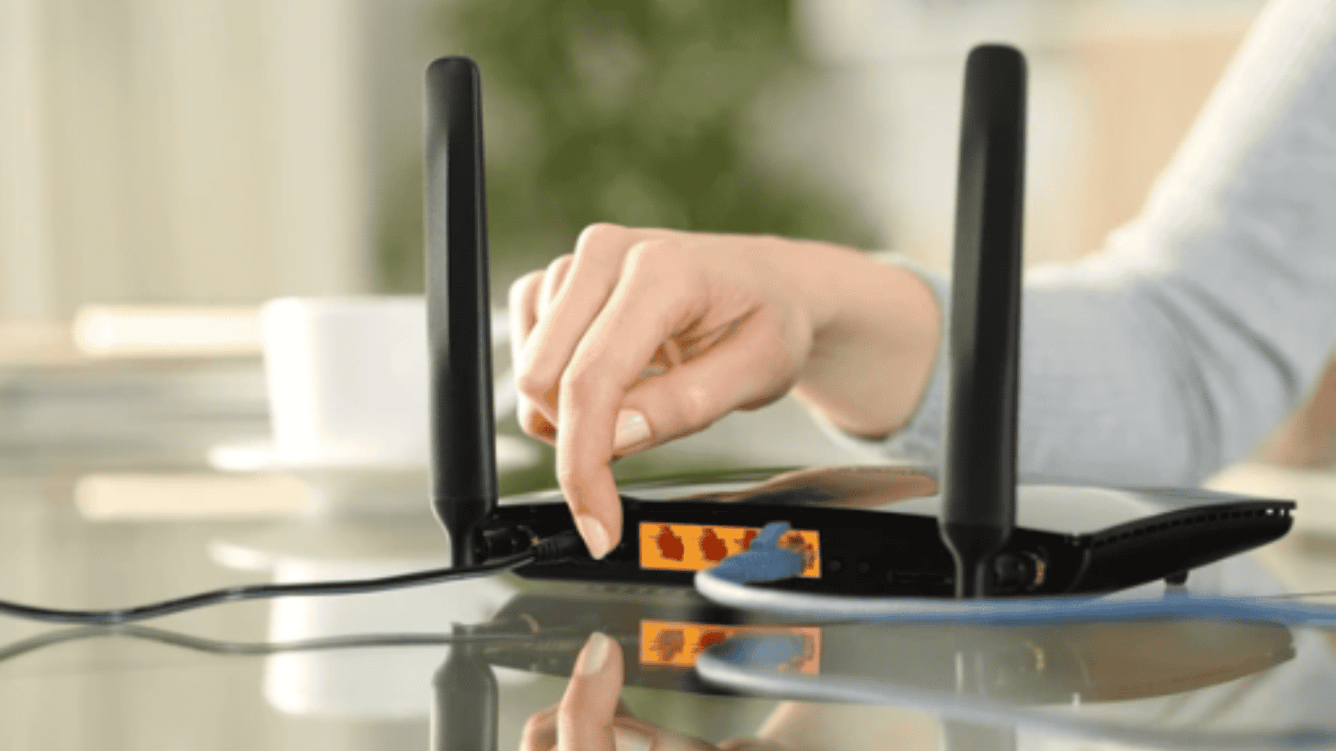mão de uma mulher reiniciando o modem apertando o botão