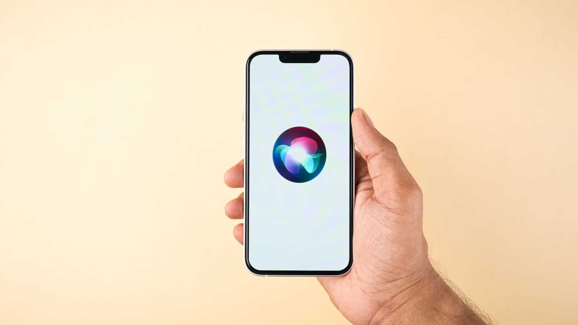Logo da Siri em um iPhone que está na mão de uma pessoa