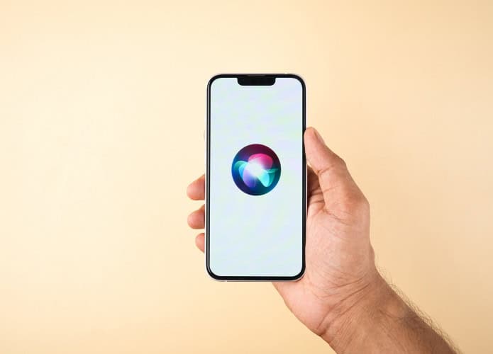 Logo da Siri em um iPhone que está na mão de uma pessoa