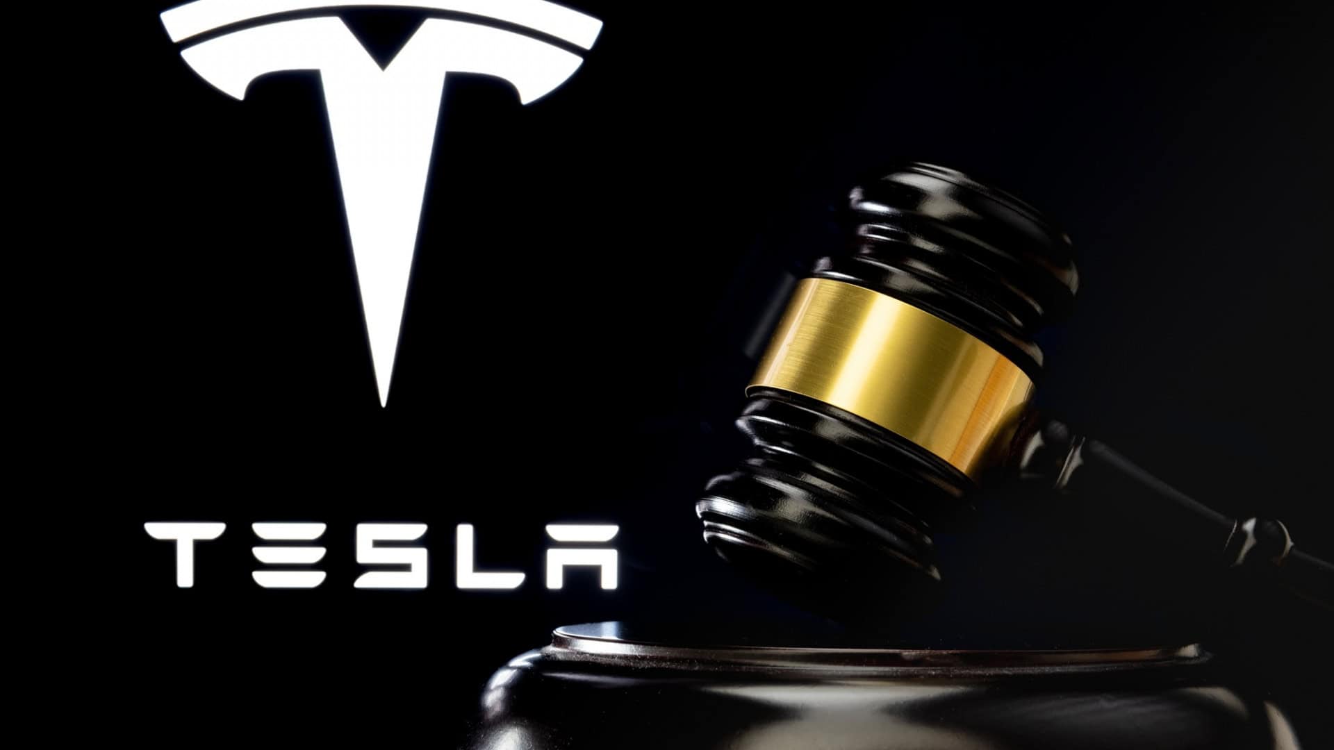 Martelo do juiz na frente e logotipo desfocado da Tesla Company visto na tela atrás.