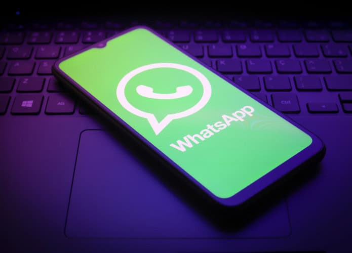 Logo do WhatsApp em um smartphone que está em cima de um teclado de notebook
