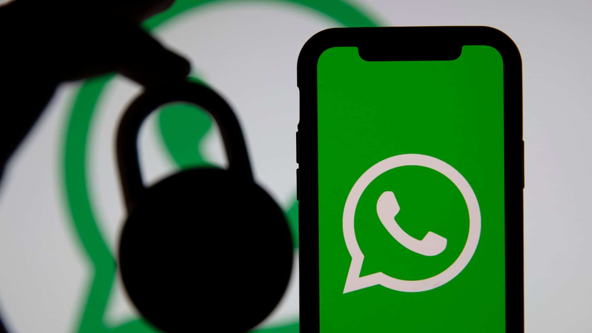 Cadeado lado de um smartphone exibindo o logo do WhatsApp