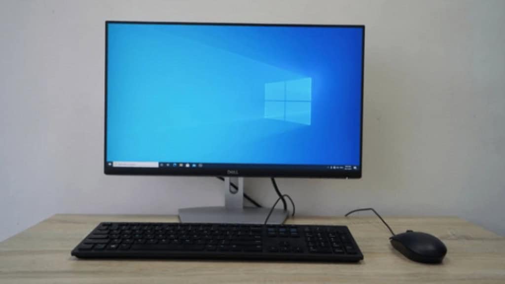 foto de um computador com tela de início do windows em cima de uma mesa