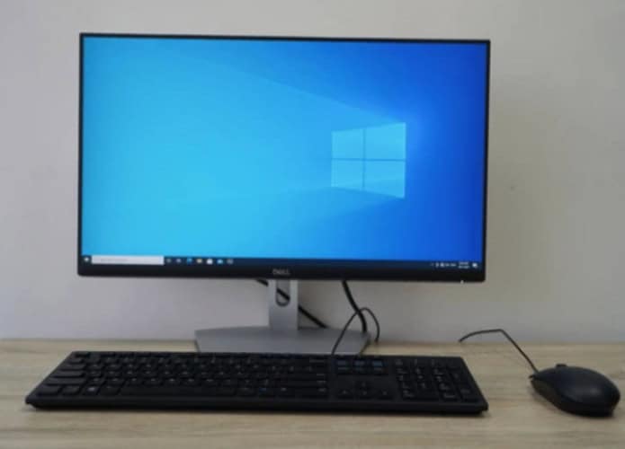foto de um computador com tela de início do windows em cima de uma mesa