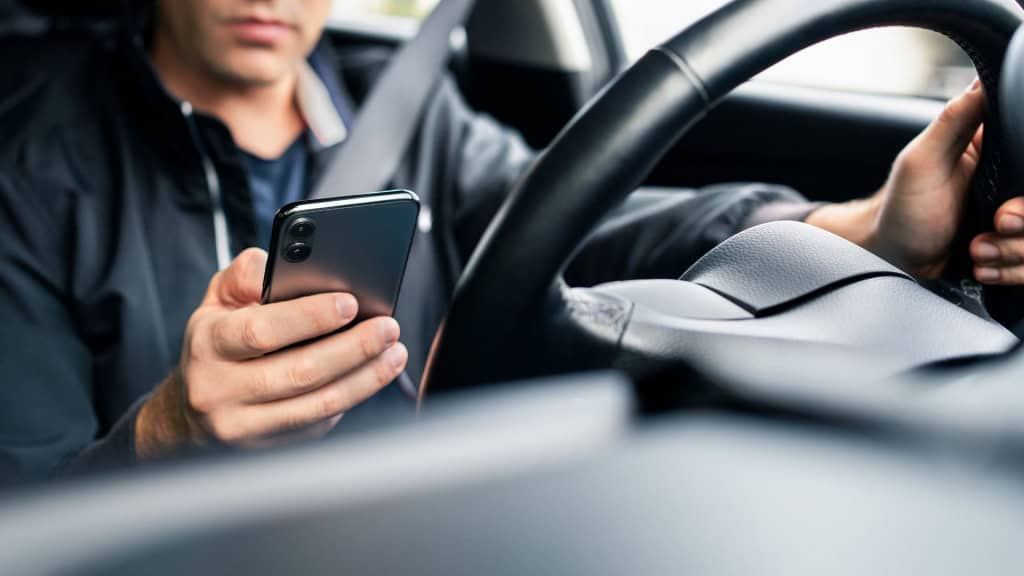Homem usando celular na estrada.