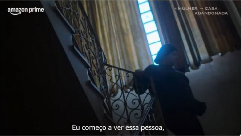 Mulher descendo escadas de casa antiga