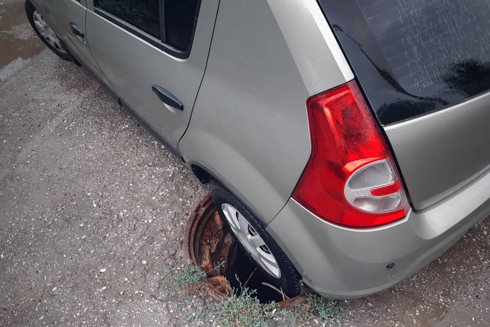 Carro afundou em bueiro