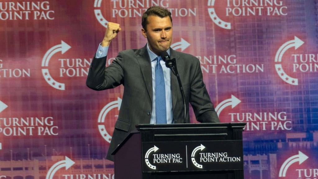 Charlie Kirk com punho para cima durante discurso