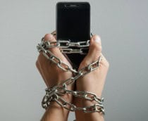 Telefone celular acorrentado às mãos de um homem, dependência do telefone