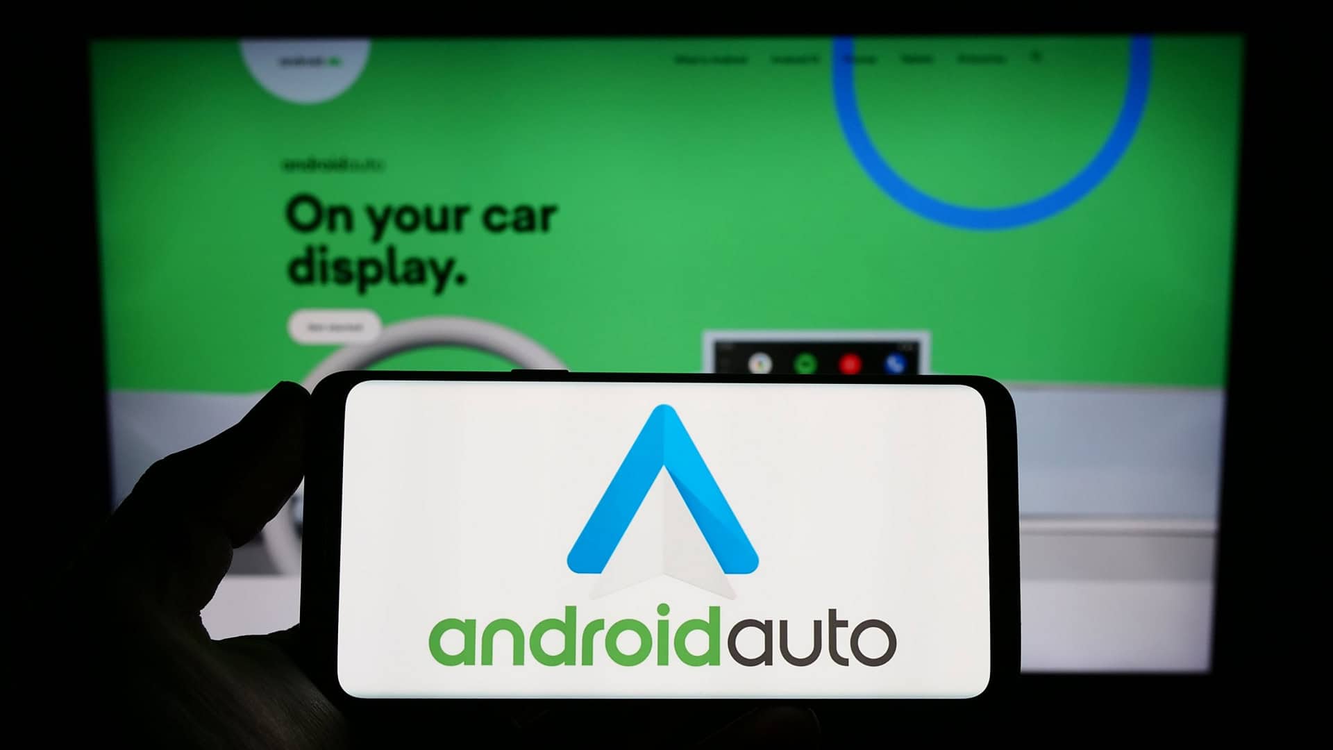 Estugarda, Alemanha - 14-03-2023: Pessoa segurando smartphone com o logotipo do aplicativo móvel Android Auto (Google) na tela em frente ao site. Foco na tela do telefone. Foto não modificada