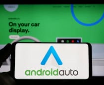 Estugarda, Alemanha - 14-03-2023: Pessoa segurando smartphone com o logotipo do aplicativo móvel Android Auto (Google) na tela em frente ao site. Foco na tela do telefone. Foto não modificada