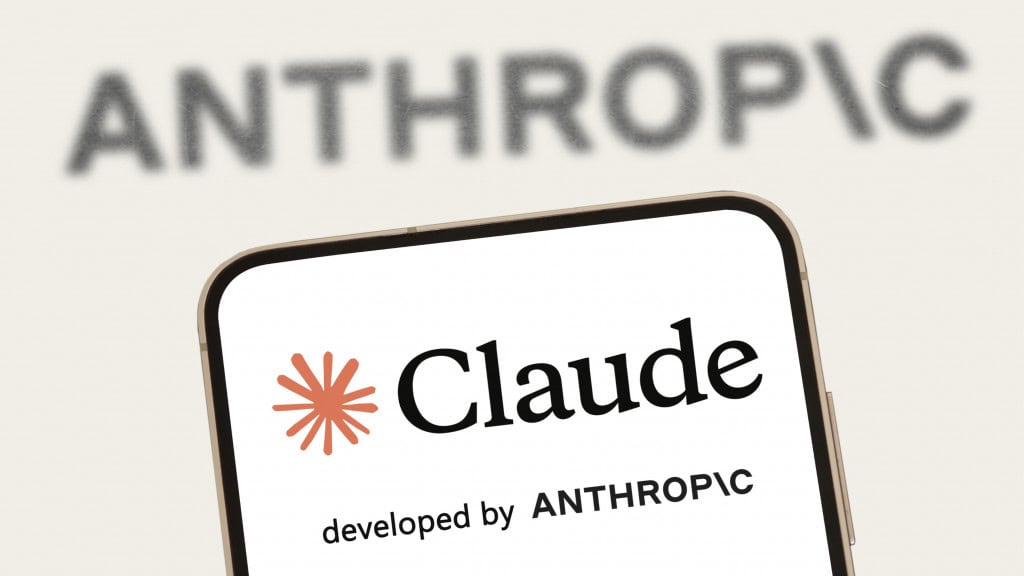 Telefone celular de logotipo Claude na tela na frente da tela maior, exibindo um sinal que é escrito antropia