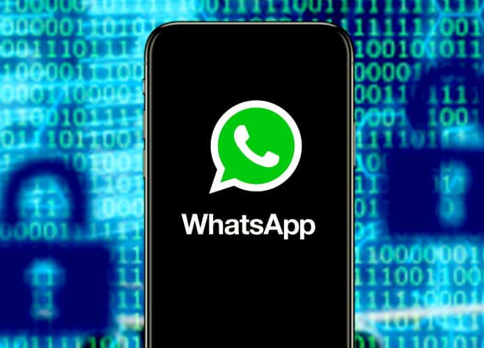 Celular com ícone do WhatsApp na tela na frente de tela mostrando códigos binários e desenhos de cadeados
