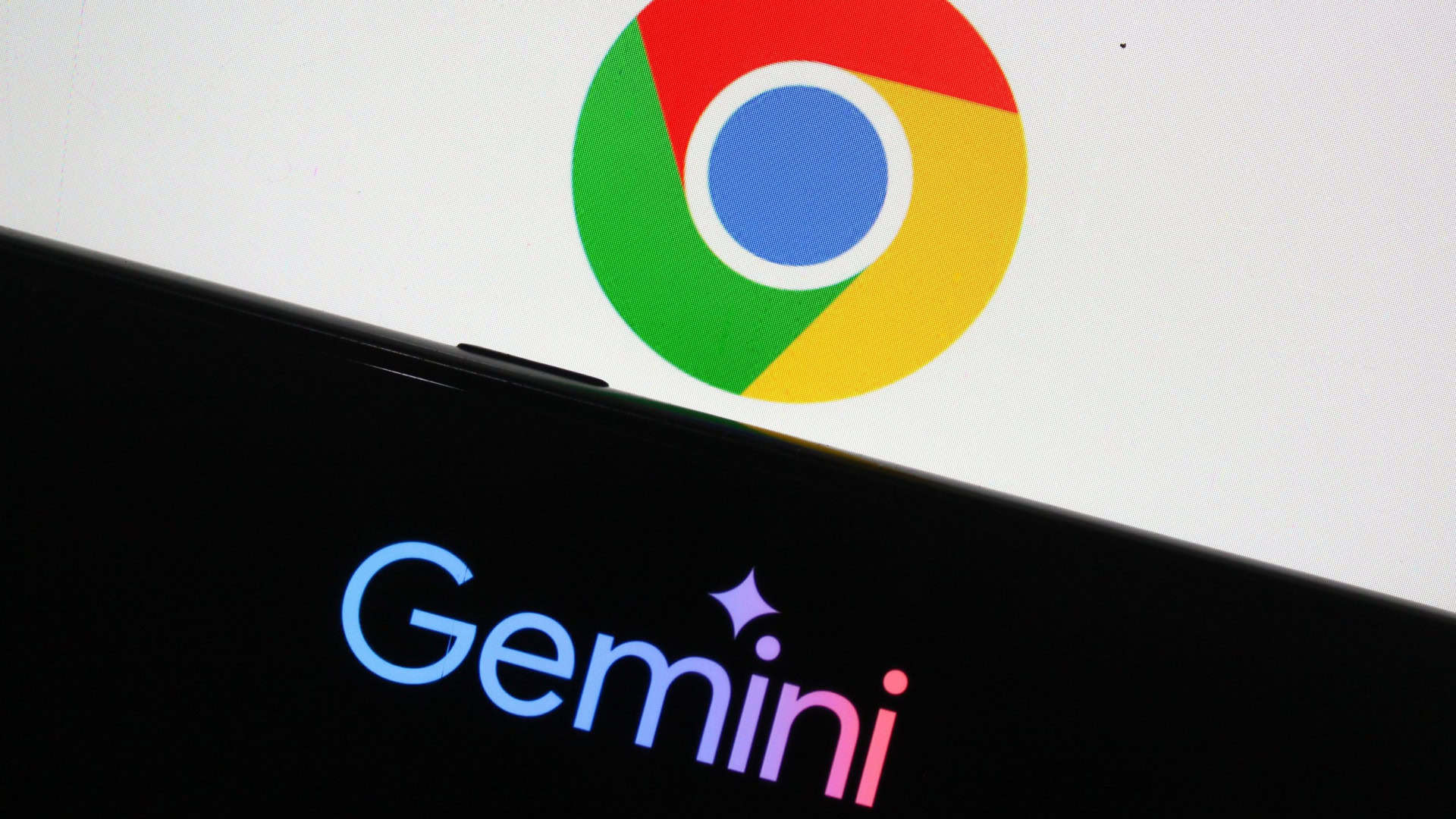Celular com logotipo do Gemini na frente de tela maior exibindo logotipo do Google Chrome