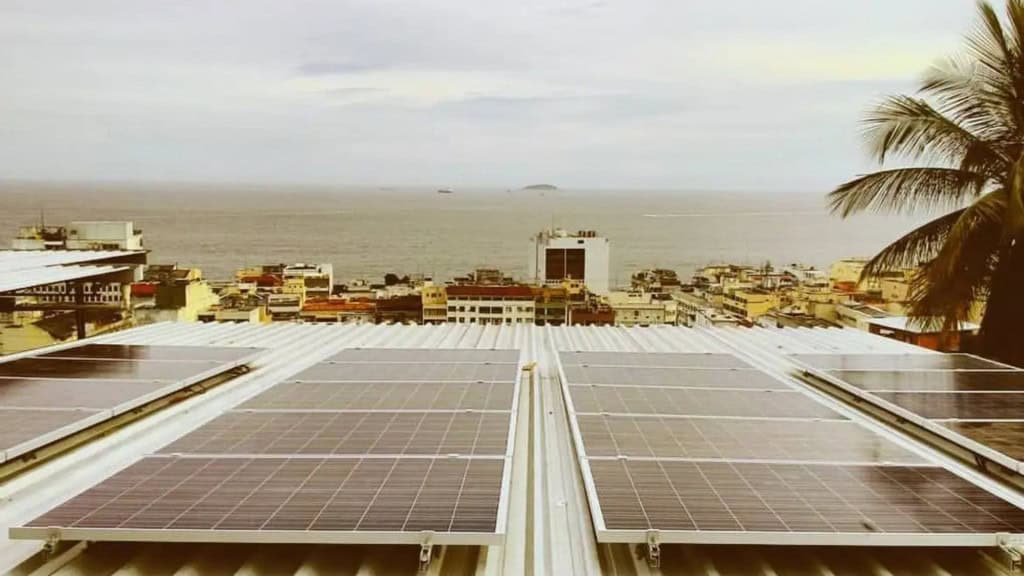 Painéis de energia solar em telhado de construção perto de praia