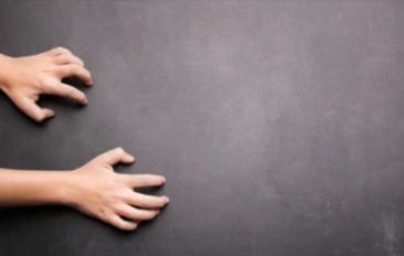 pessoa com as unhas em uma lousa preta