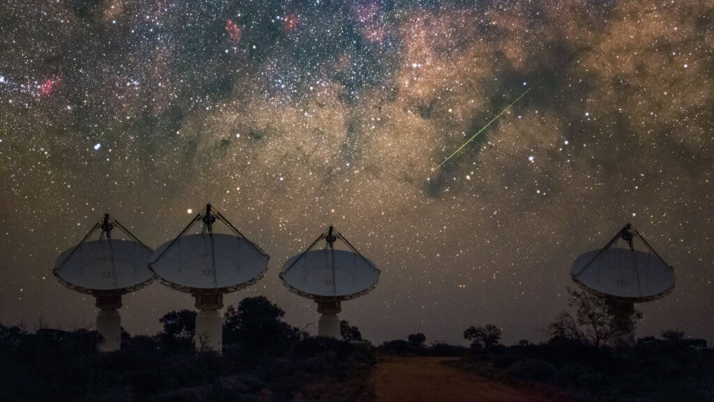 Quatro antenas de radiotelescópios sob céu muito estrelado