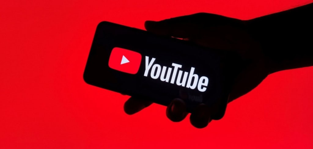 Logo do YouTube em um smartphone que está na mão de uma pessoa e na horizontal