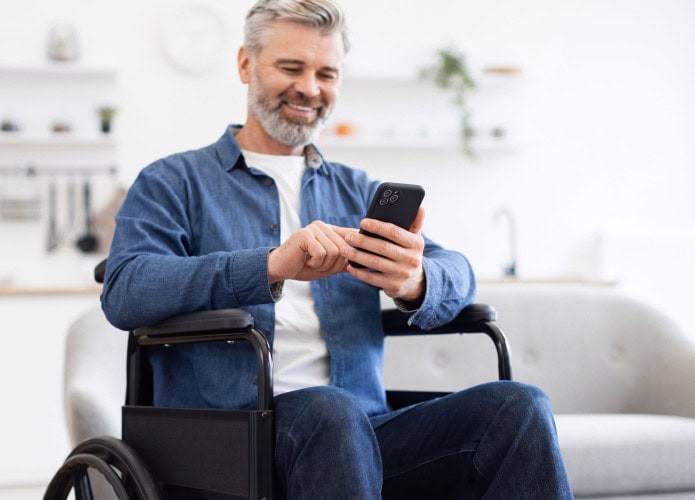 Homem sentado em cadeira de rodas usando smartphone