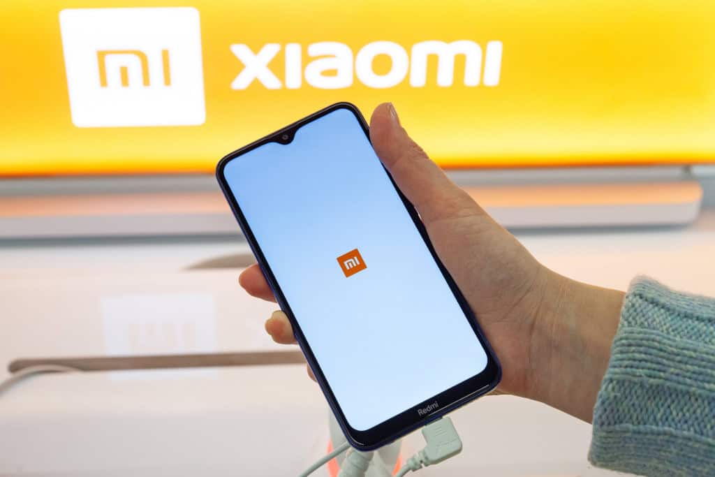 Pessoa com celular na mão com a logo da Xiaomi