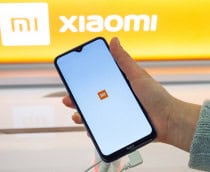 Pessoa com celular na mão com a logo da Xiaomi