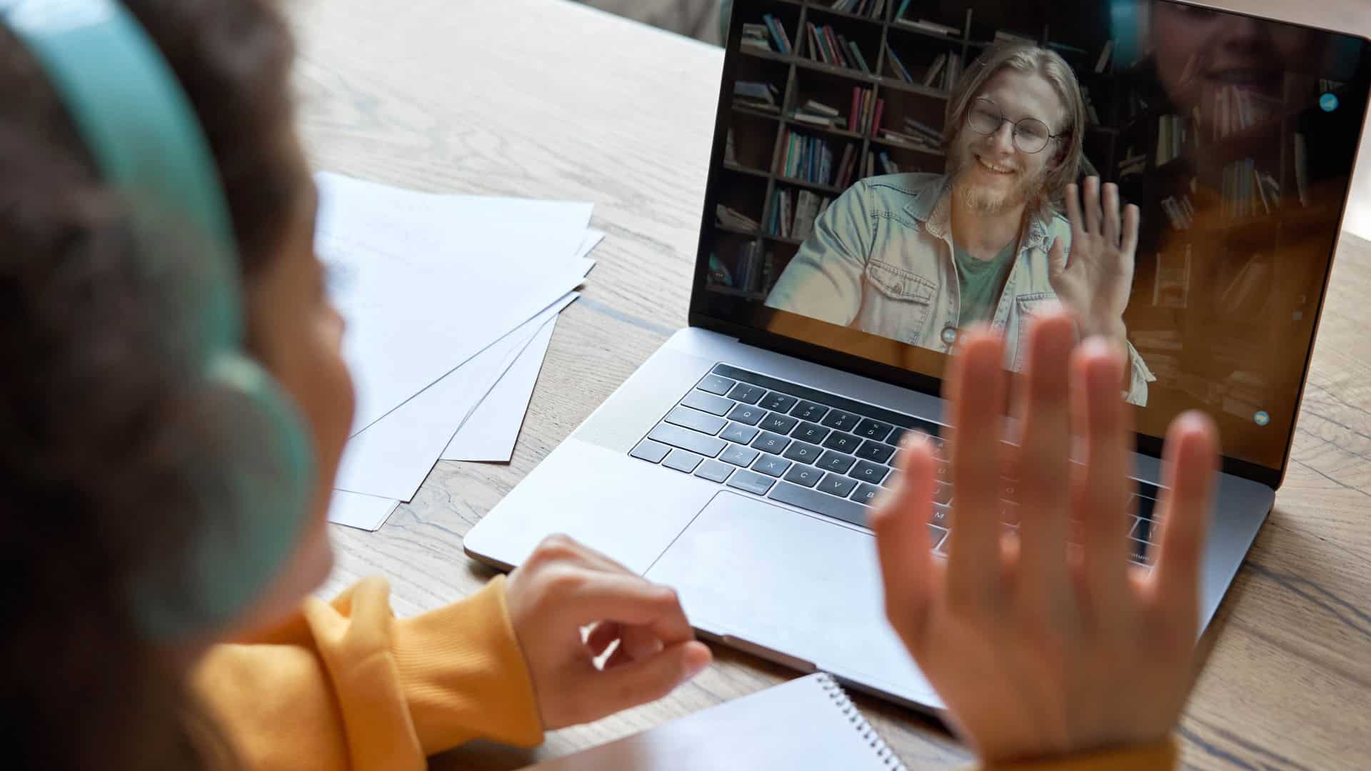 Criança com fone de ouvido conversando em aplicativo de vídeo no notebook