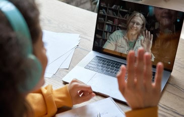 Criança com fone de ouvido conversando em aplicativo de vídeo no notebook