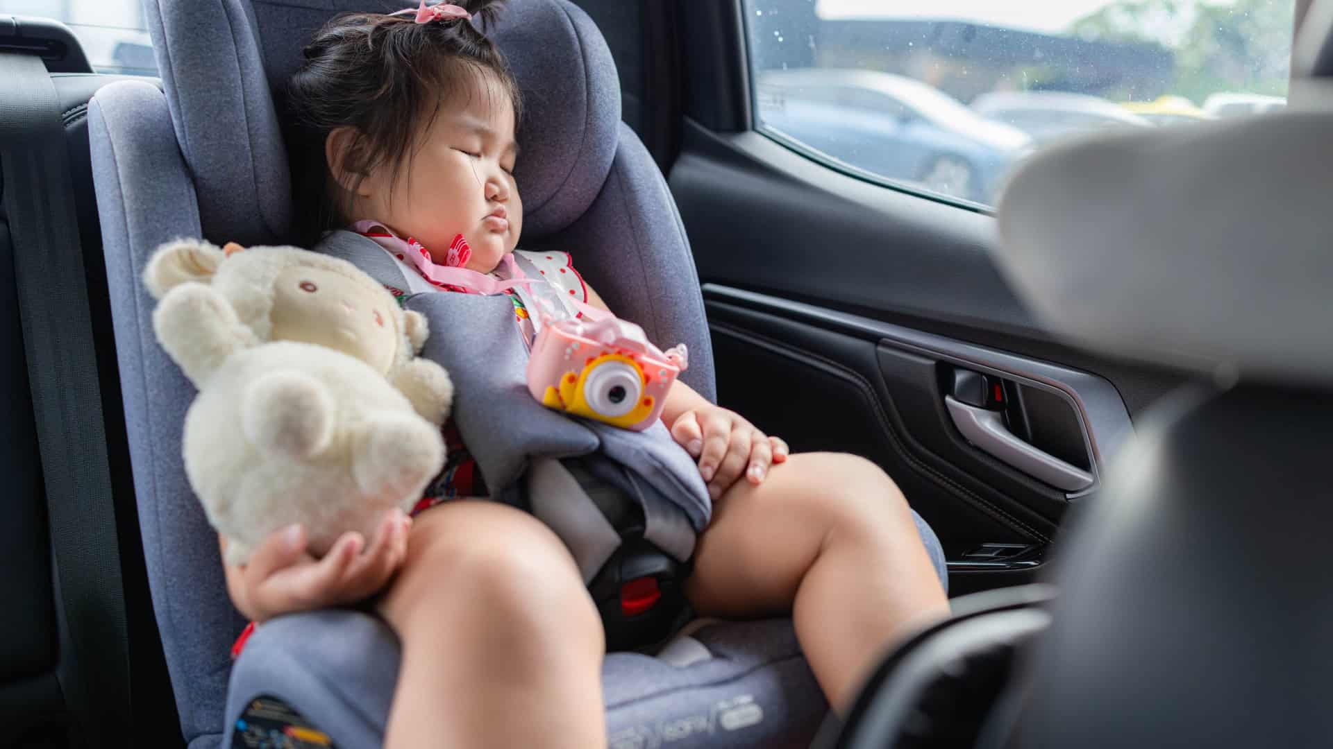 Criança dormindo na cadeirinha do carro