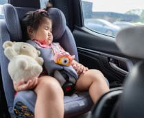 Criança dormindo na cadeirinha do carro
