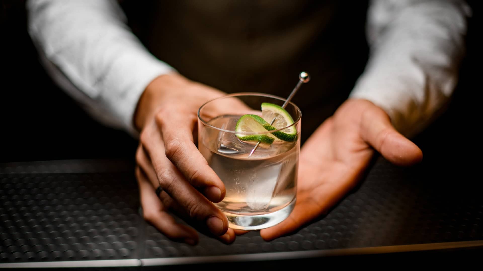 Bartender segura drink alcoólico nas mãos
