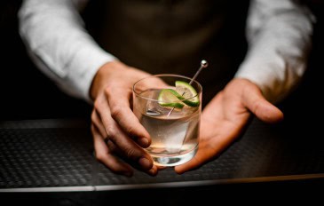 Bartender segura drink alcoólico nas mãos