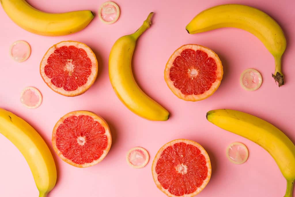 Imagem ilustrativa promovendo a educação sexual com  bananas, toranjas e preservativos para sexo seguro