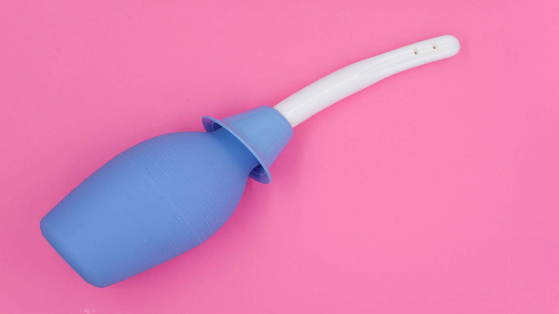 Imagem ilustrativa de uma ducha íntima ou ducha vaginal em fundo isolado rosa