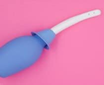 Imagem ilustrativa de uma ducha íntima ou ducha vaginal em fundo isolado rosa