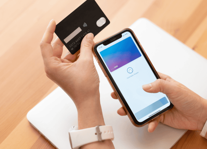 mulher segurando o celular enquanto adiciona o cartão em uma carteira digital