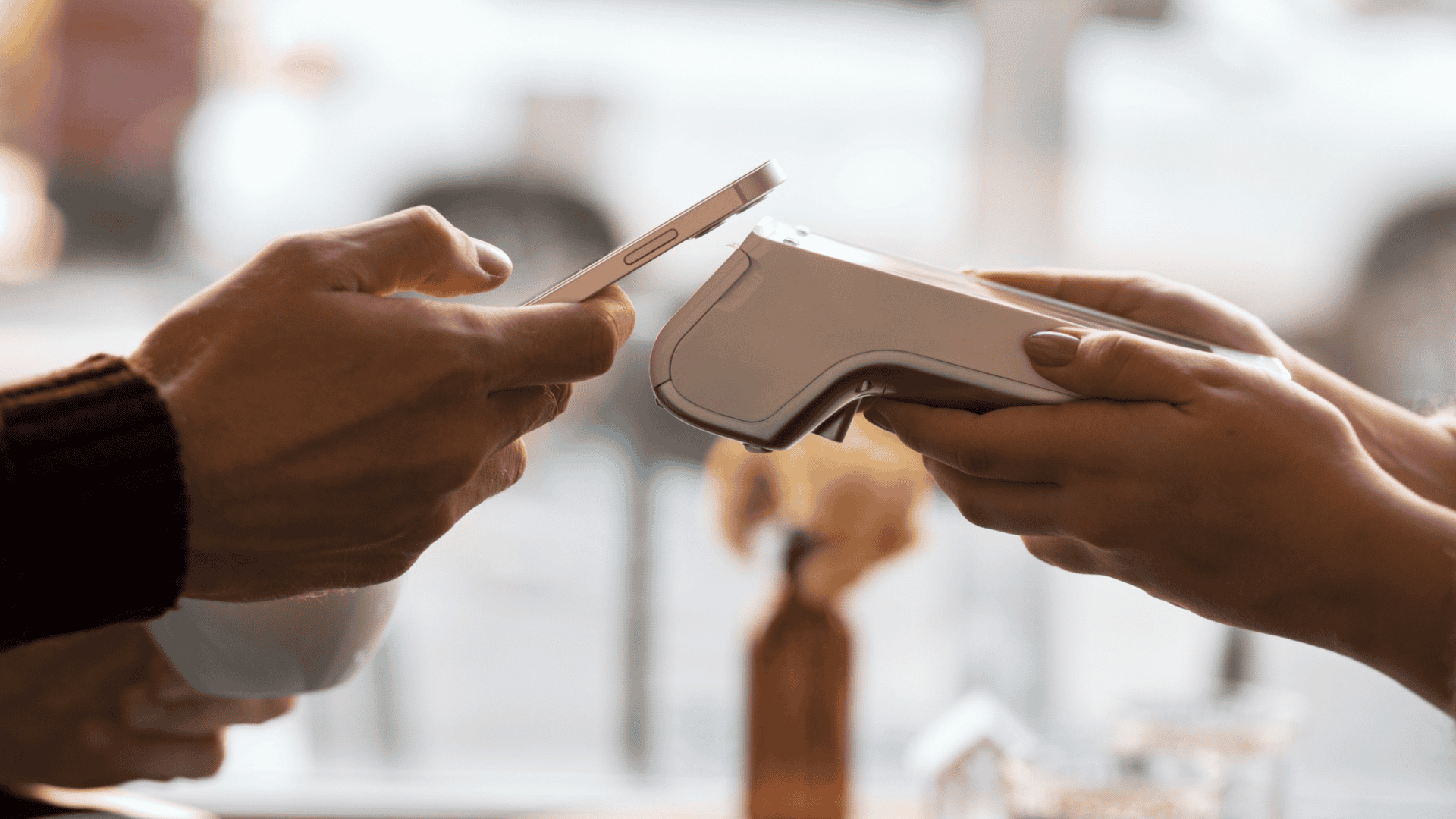 pessoa fazendo pagamento em máquina de cartão com o celular, por aproximação