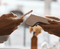 pessoa fazendo pagamento em máquina de cartão com o celular, por aproximação