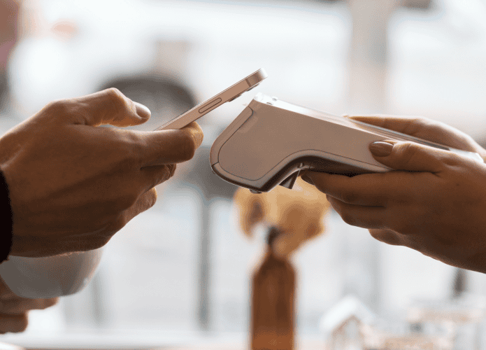 pessoa fazendo pagamento em máquina de cartão com o celular, por aproximação