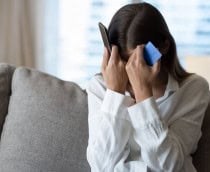 Mulher desesperada ao telefone ao sofrer um golpe